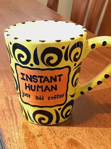 Coffee_human Photo of a yellow coffee mug with the phrase INSTANT HUMAN just add coffee